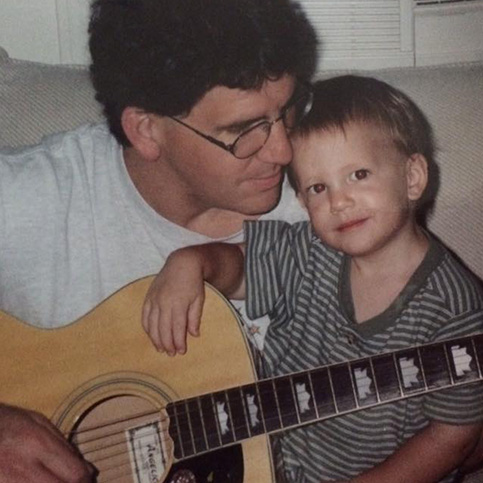 Dr. Tortland playing guitar with one of his children