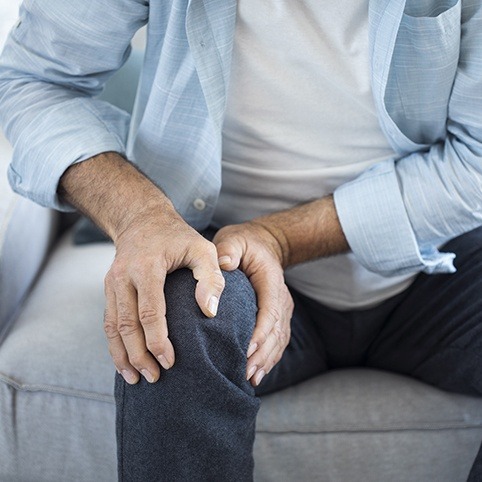 Person in pain holding knee