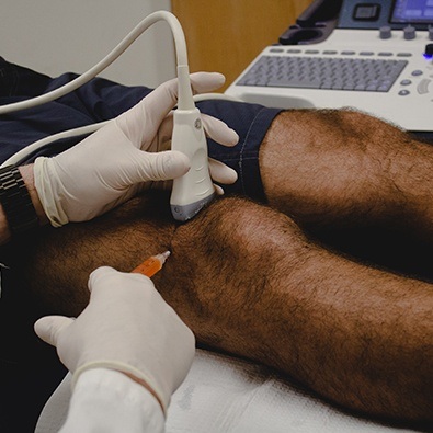 Doctor administering knee injection