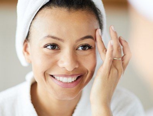 Woman looking at face in mirror