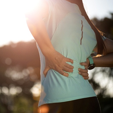 woman taking a break from running due to back pain