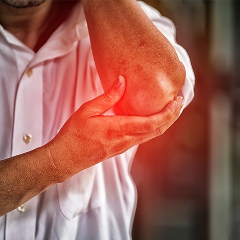 Person in pain holding elbow