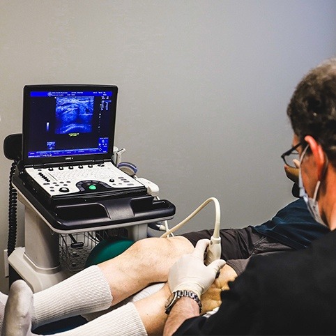 Dcotor examining patient's knee