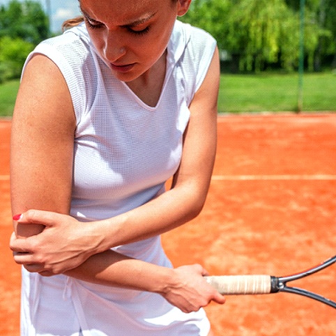 female tennis player experiencing Tennis Elbow