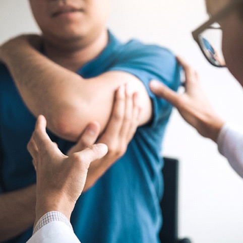 doctor examining patient with Tennis Elbow