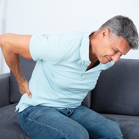 Man in pain holding his lower back