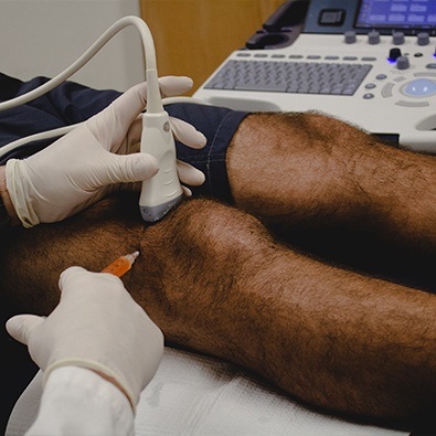 Doctor administering knee injection