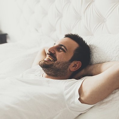 Smiling man laying in bed