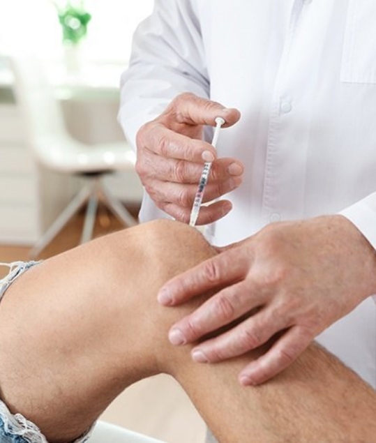 Doctor administering injection in knee