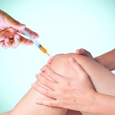 Doctor placing injection in knee