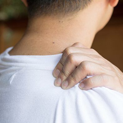 Person in pain massaging shoulder