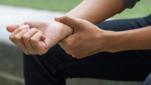 man with Carpal Tunnel Syndrome holding wrist  