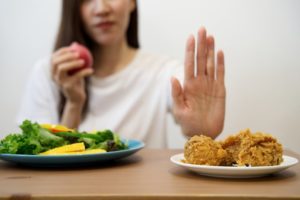 woman with osteoarthritis rejecting fried chicken  