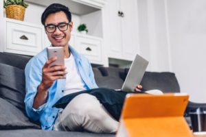 man looking at phone while working at home