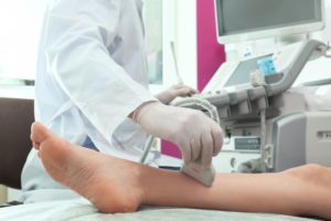 doctor using ultrasound on a patient’s ankle 