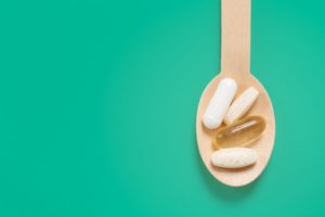 wooden spoon holding supplement pills 