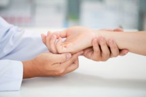 Doctor examining patient for carpel tunnel syndrome, a condition treatable via nerve hydrodissection