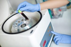 Medical team member placing blood in centrifuge