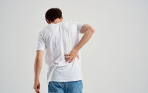 Man in white t-shirt experiencing back pain